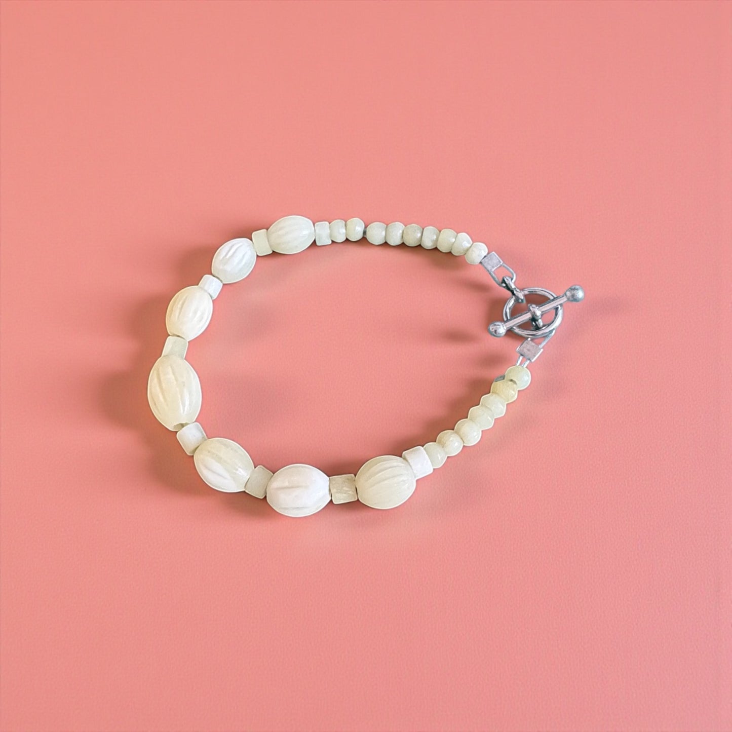 Beaded bracelet with a clasp on a pink background