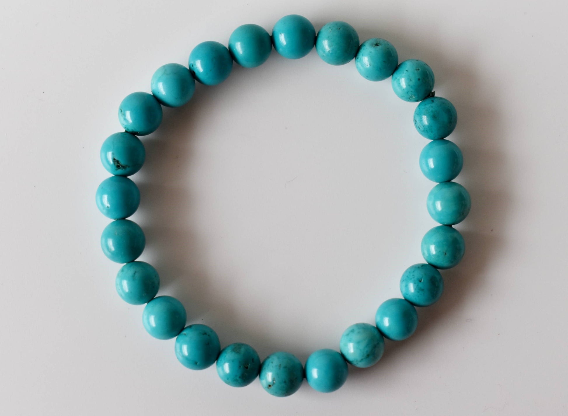 Turquoise beaded bracelet on a light gray background