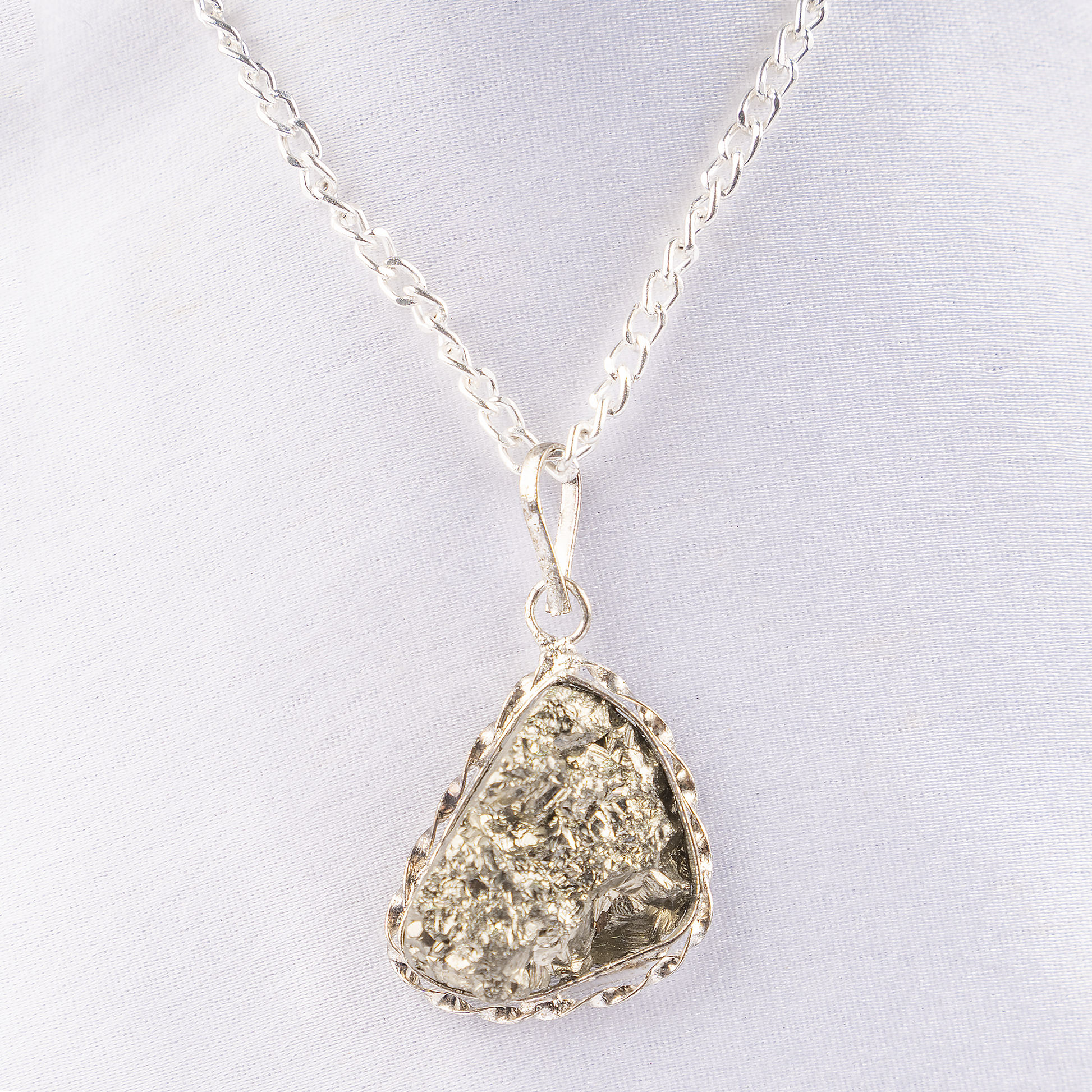 Silver necklace with a teardrop-shaped pendant on a light gray background
