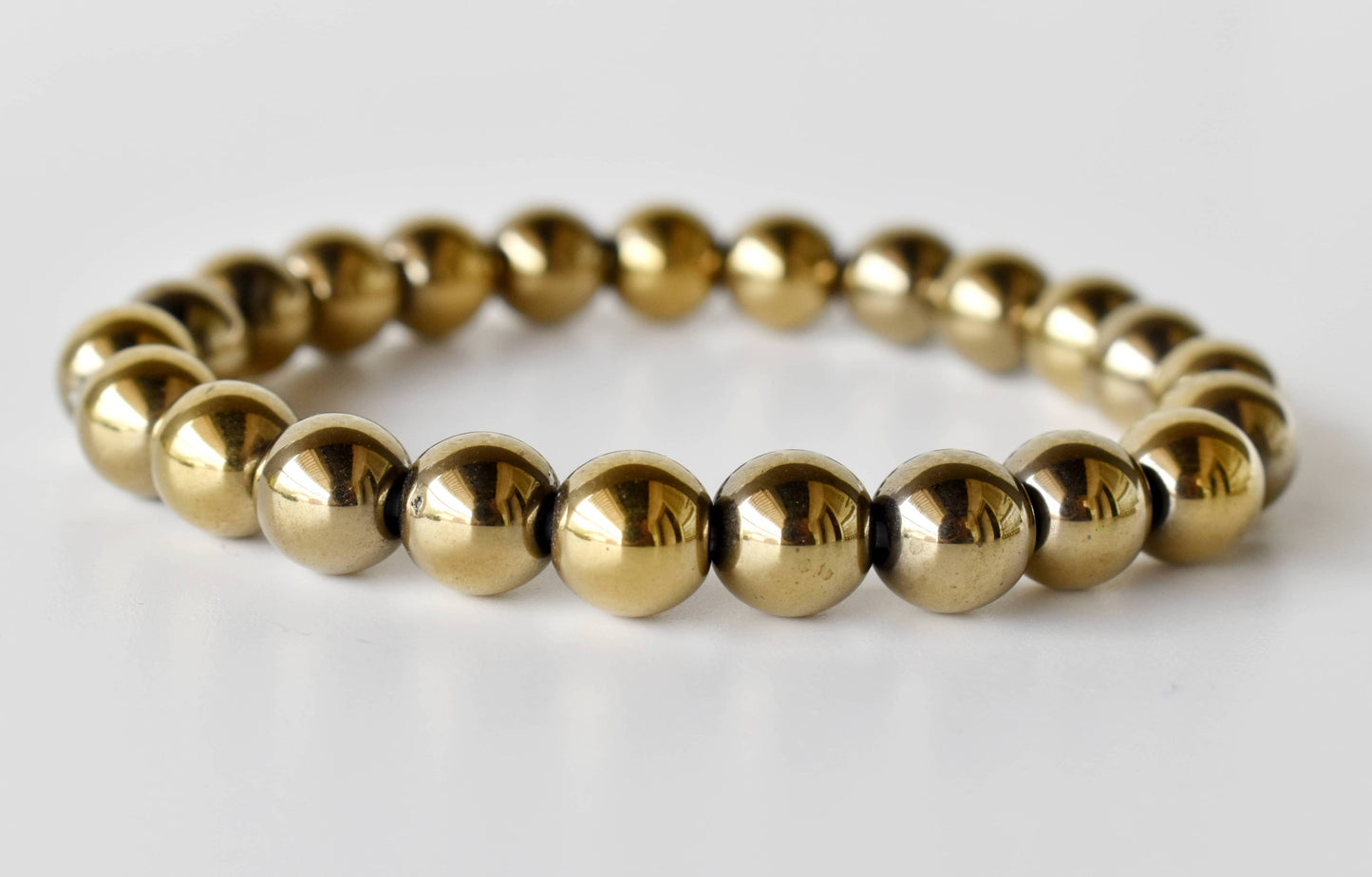 Gold beaded bracelet on a white background