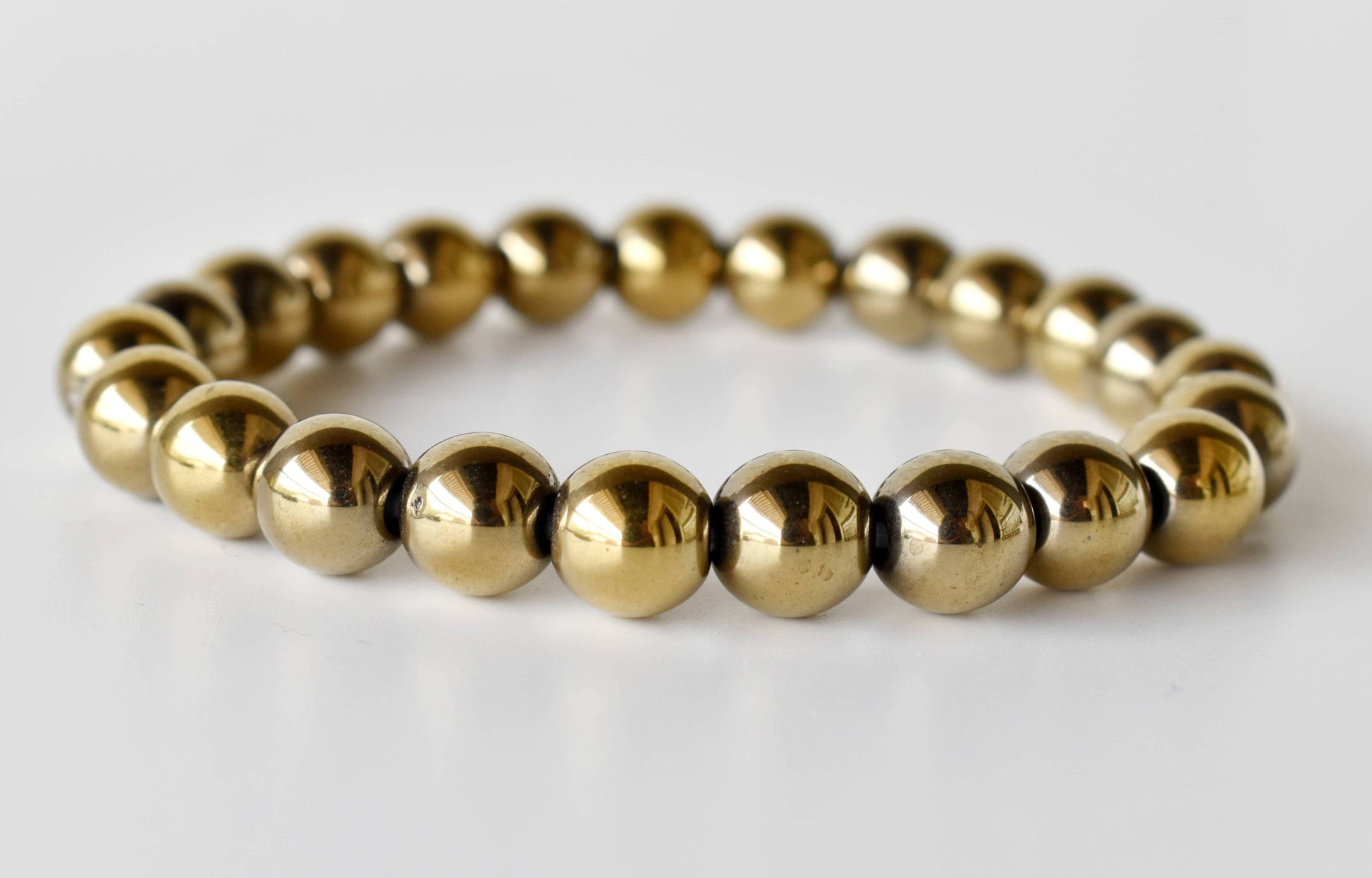 Gold beaded bracelet on a white background
