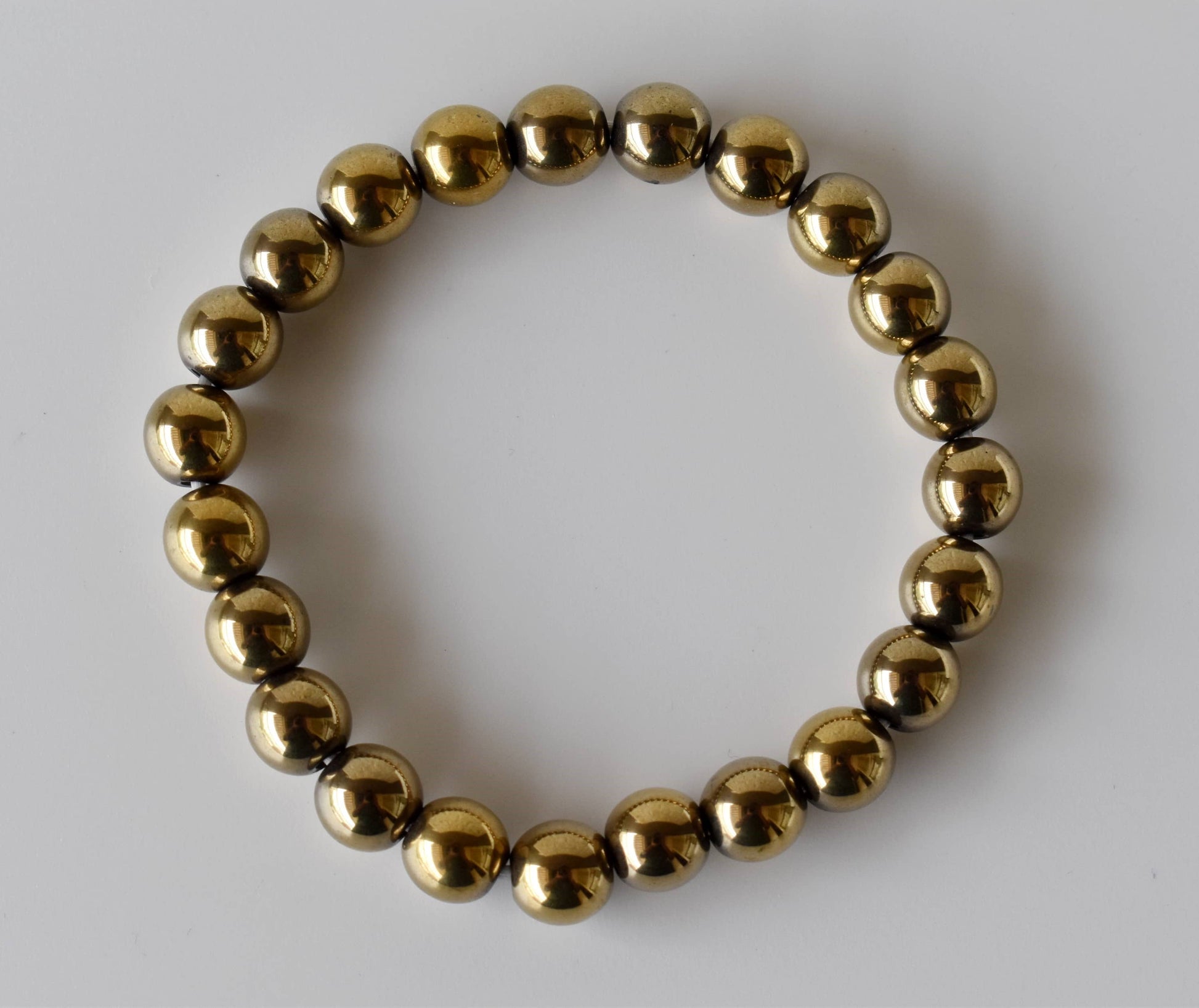 Gold beaded bracelet on a white background