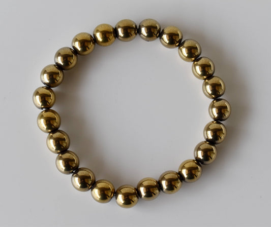 Gold beaded bracelet on a white background