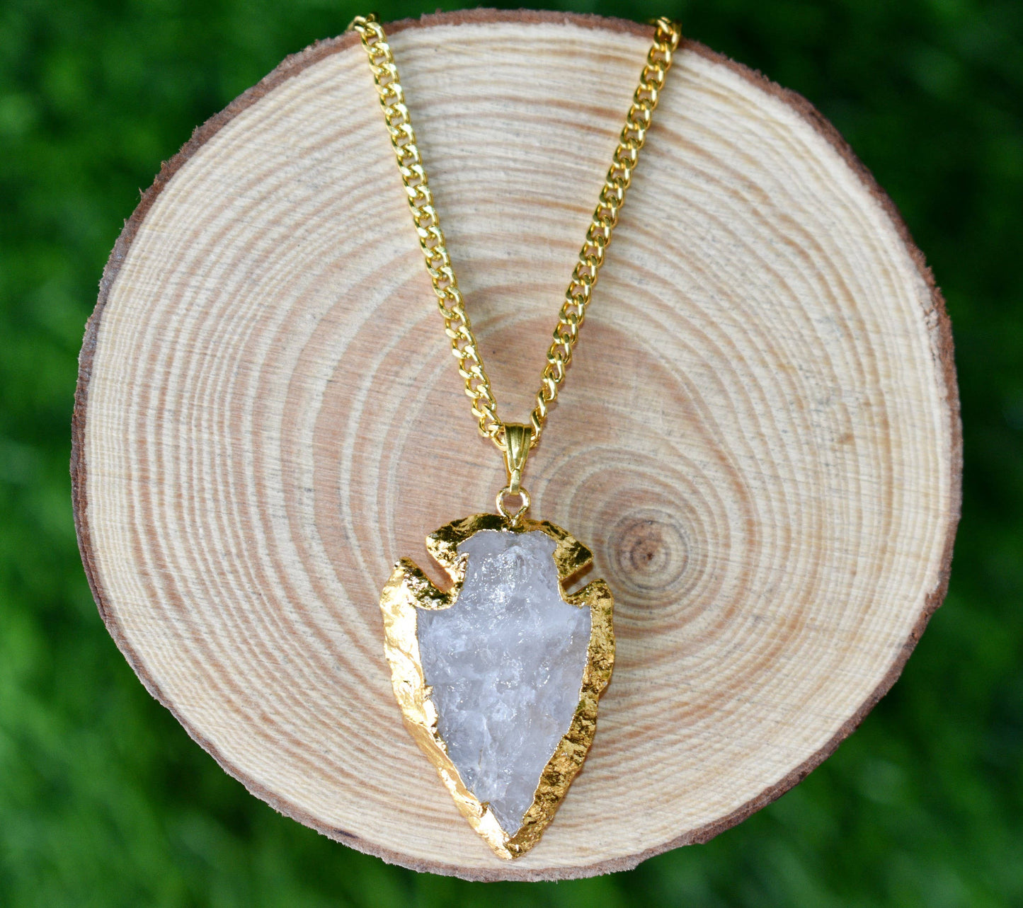 Necklace with a gold and crystal pendant on a wooden surface