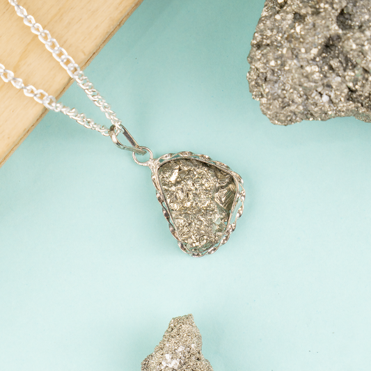 Necklace with a silver pendant resembling a crystal on a light blue background