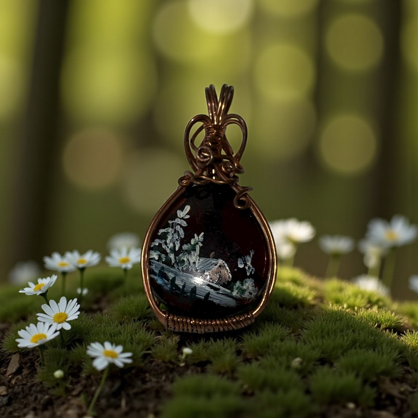 Jewelry pendant with nature scene on a blurred forest background