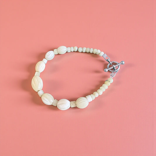 Beaded bracelet with a clasp on a pink background