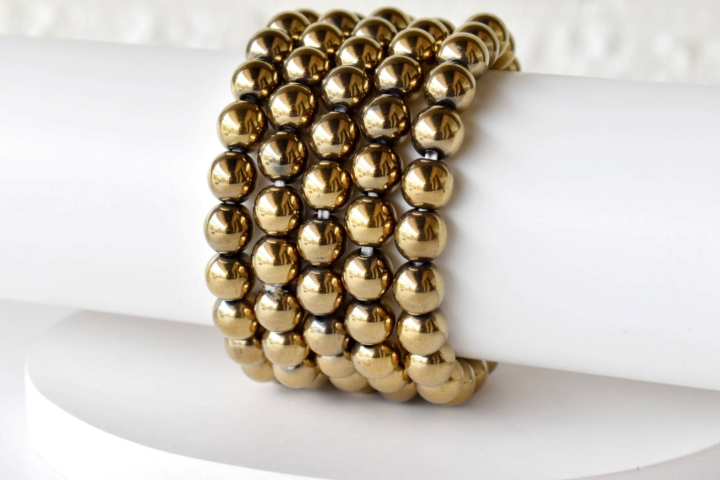 Gold beaded bracelet on a white surface
