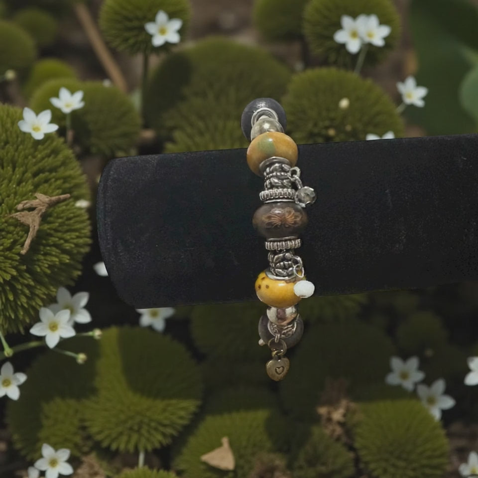 Earthy bohemian charm bracelet with carved wood beads and silver chain